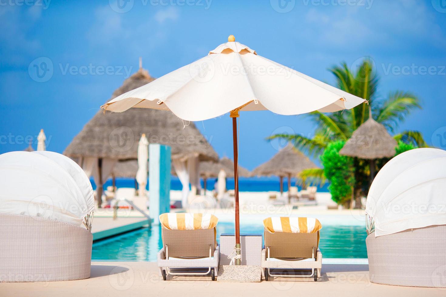 chaises longues et parasol dans un magnifique complexe tropical photo