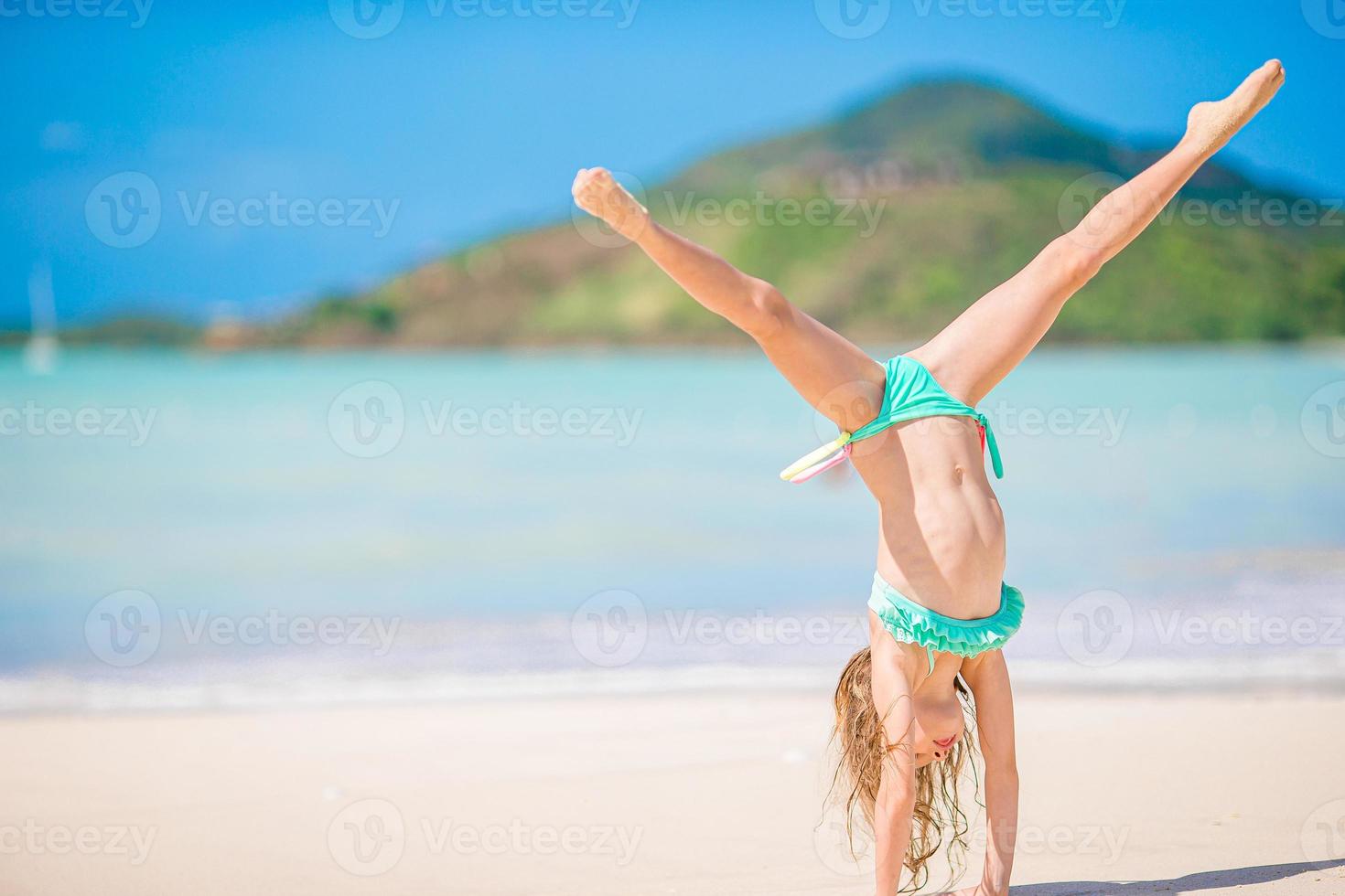 adorable petite fille active à la plage pendant les vacances d'été photo