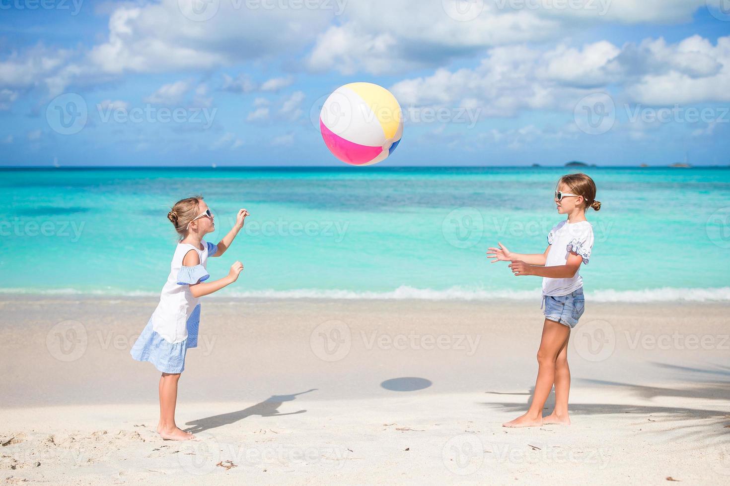 petites filles adorables jouant au ballon sur la plage. les enfants  s'amusent au bord de la mer 17751846 Photo de stock chez Vecteezy