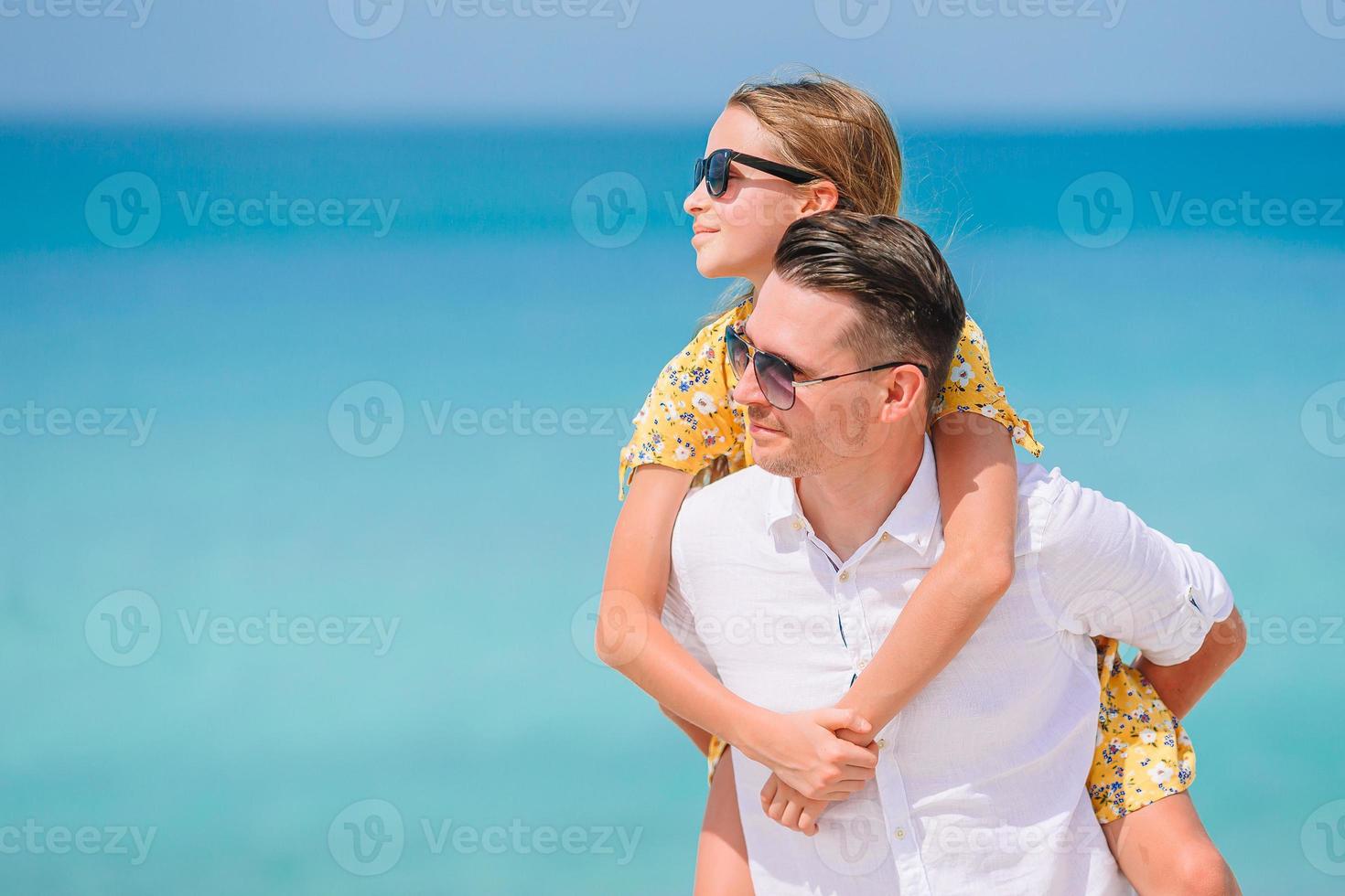 petite fille et papa heureux s'amusant pendant les vacances à la plage photo