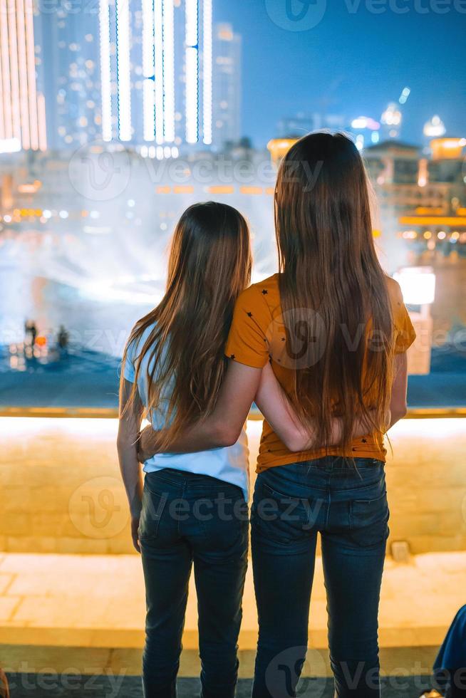 les petites filles regardent le spectacle légendaire des fontaines chantantes à dubai photo