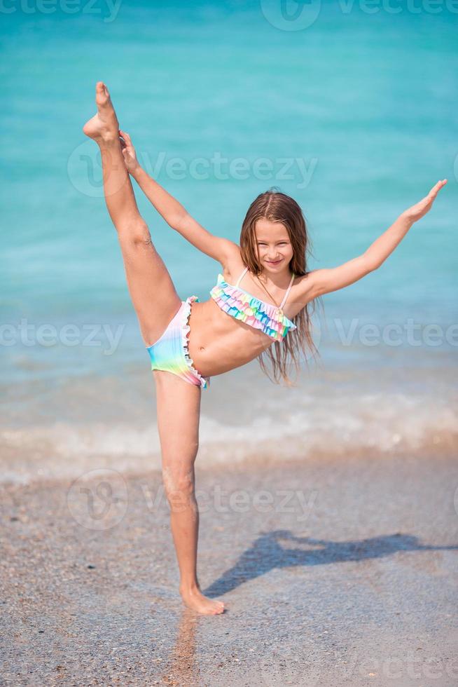 adorable petite fille heureuse s'amuser en vacances à la plage photo