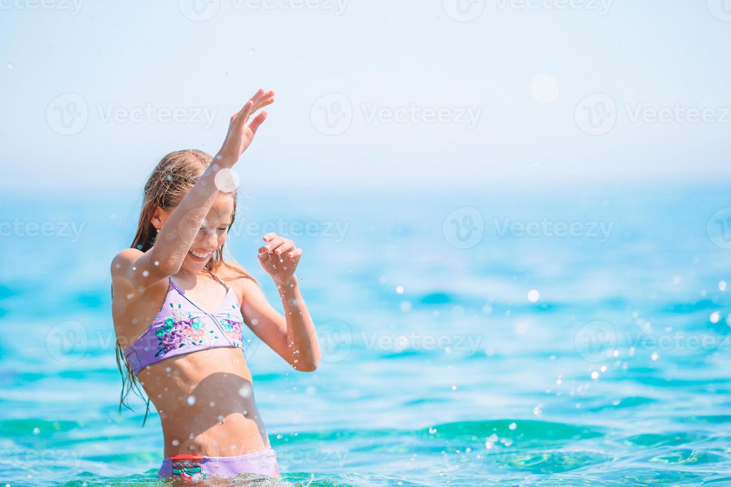 jolie petite fille à la plage pendant les vacances d'été photo