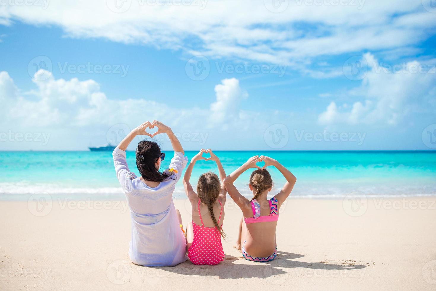 adorables petites filles et jeune mère sur la plage blanche photo