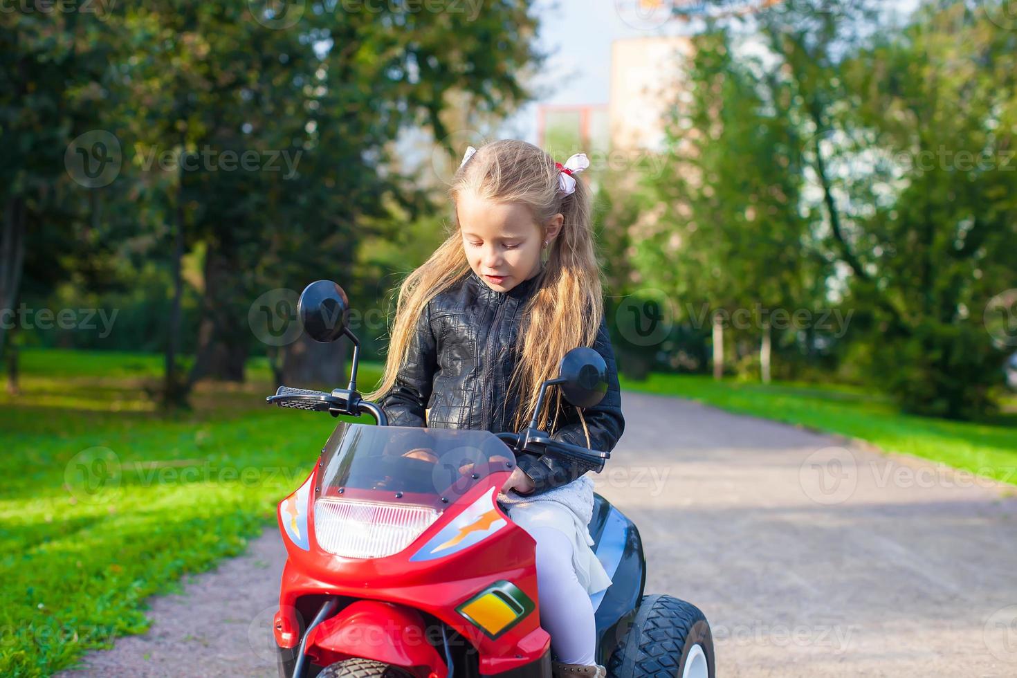 petite fille adorable sur sa moto jouet 17757753 Photo de stock chez  Vecteezy