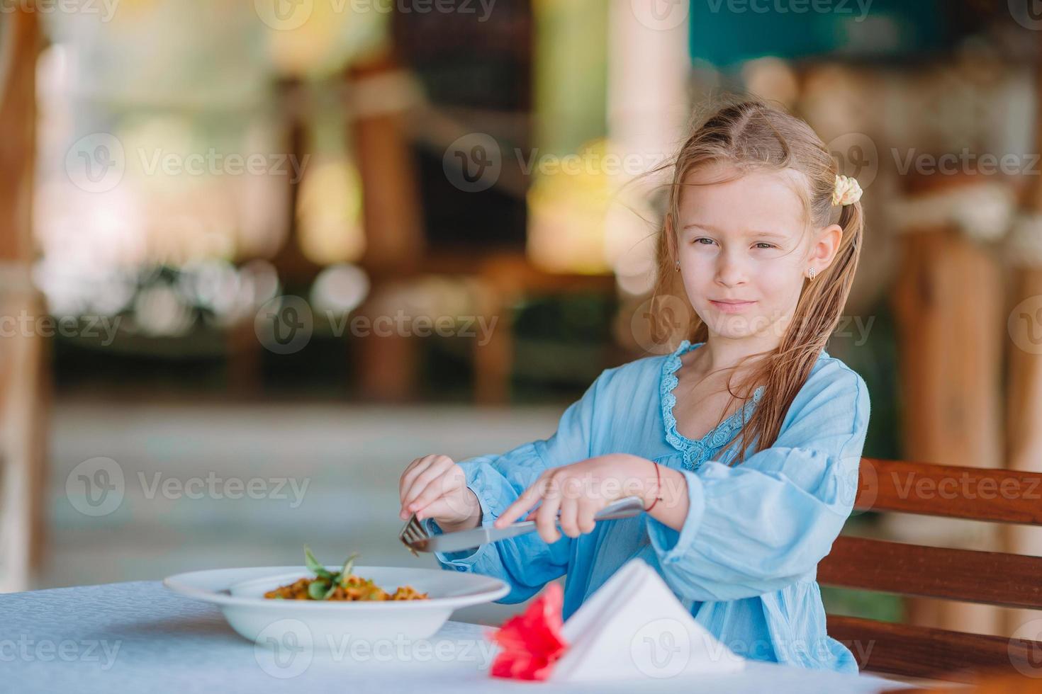 adorable petite fille en train de dîner au café en plein air photo