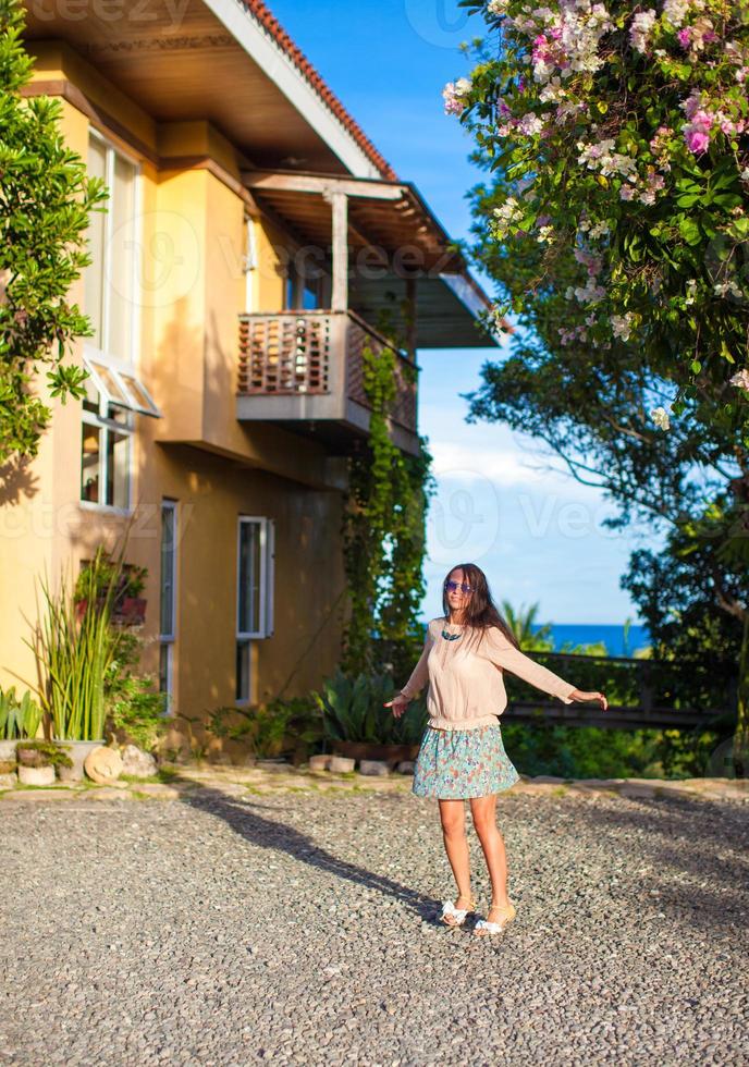 jeune femme brune se relaxant dans la cour de la belle maison photo