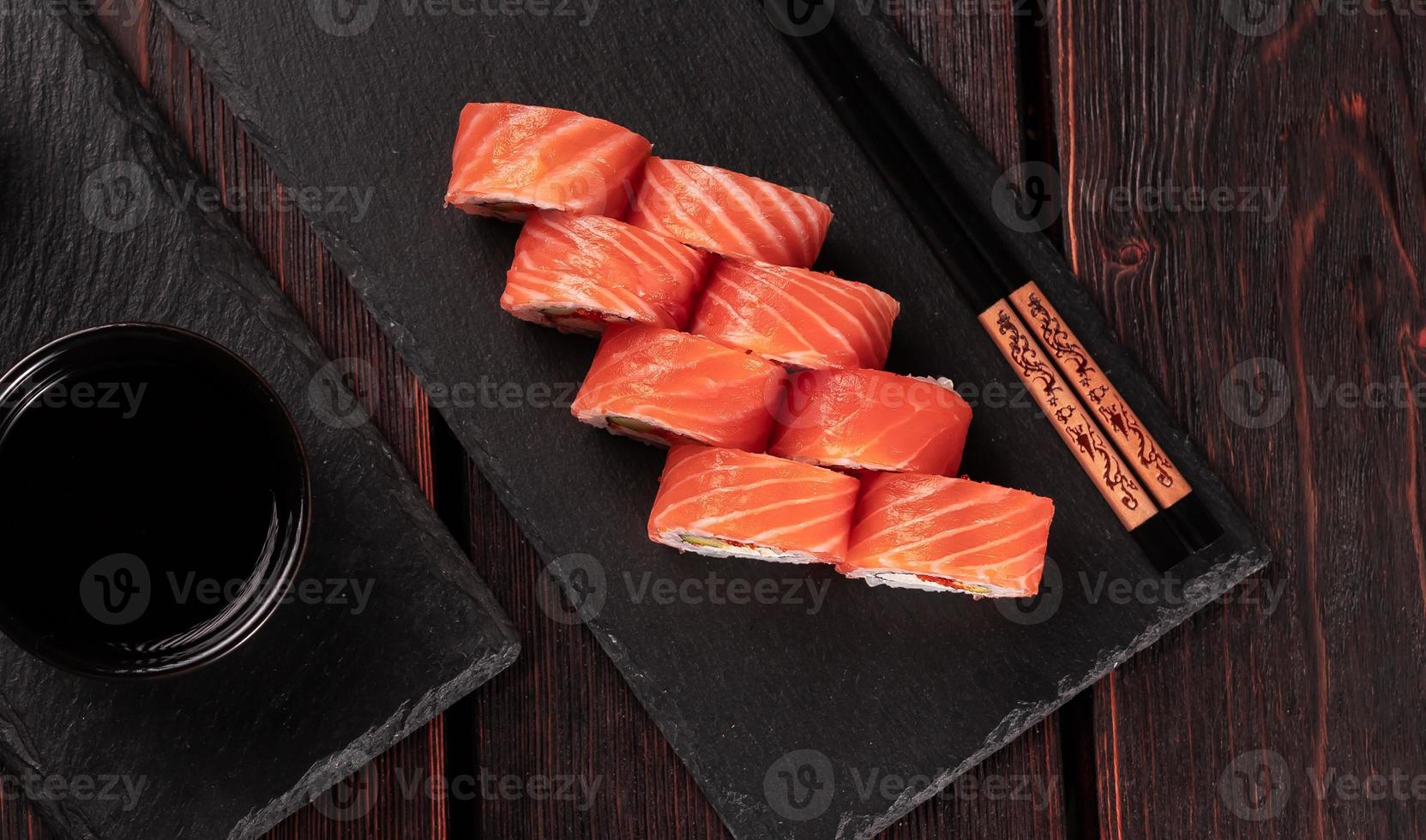 rouler avec des sushis de poisson et des baguettes vue de dessus en gros plan - concept de cuisine asiatique photo