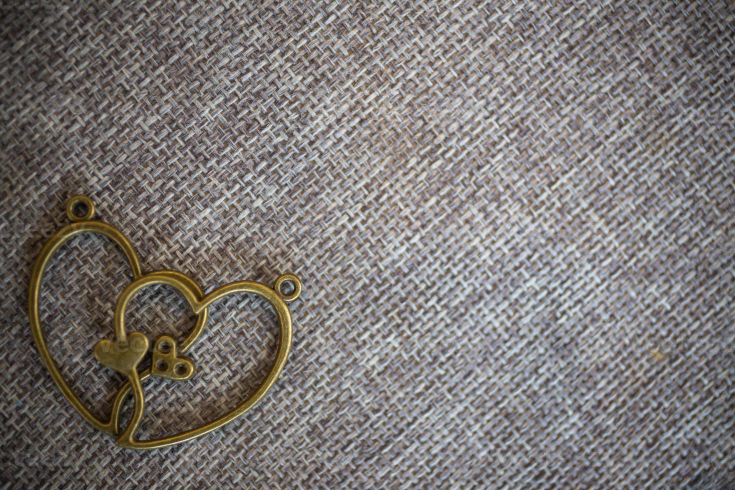 pendentif coeur sur vieux tissu, fond de texture, concept de la Saint-Valentin photo