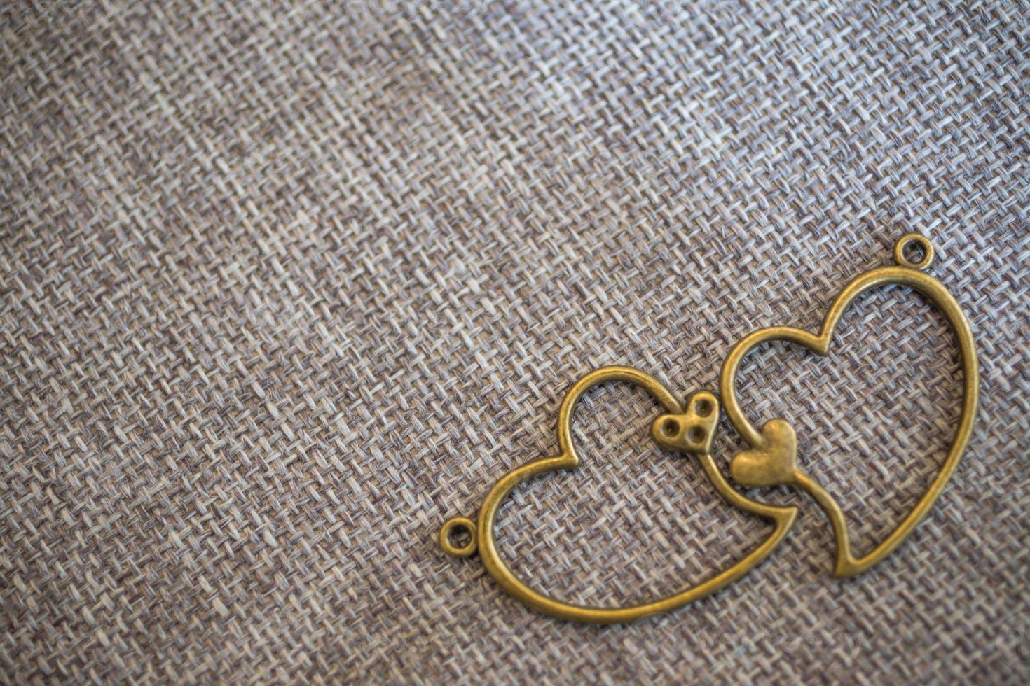 pendentif coeur sur vieux tissu, fond de texture, concept de la Saint-Valentin photo