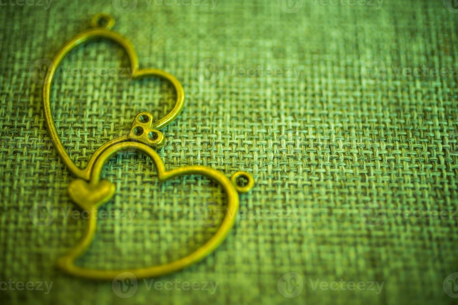 pendentif coeur sur vieux tissu, fond de texture, concept de la Saint-Valentin photo
