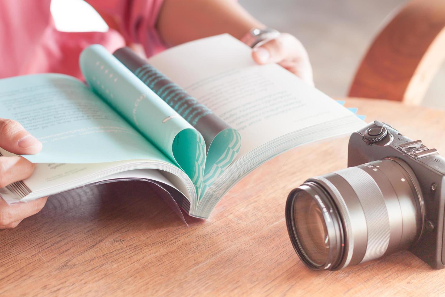 femme lisant un livre avec un appareil photo