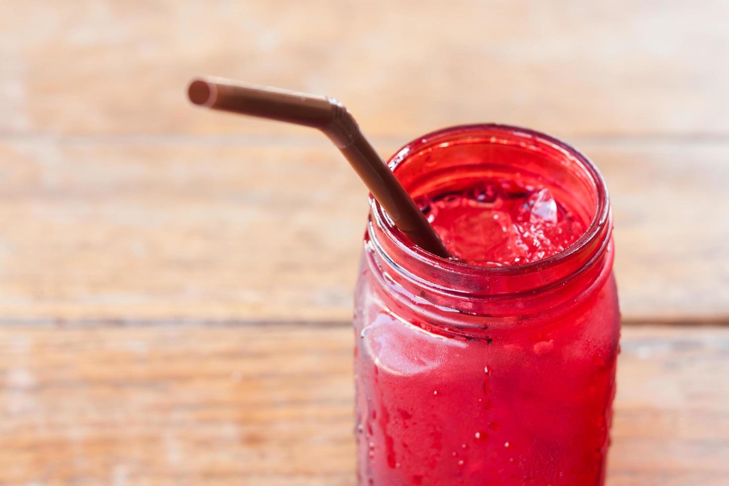 Gros plan d'une boisson glacée en verre rouge sur une table en bois photo