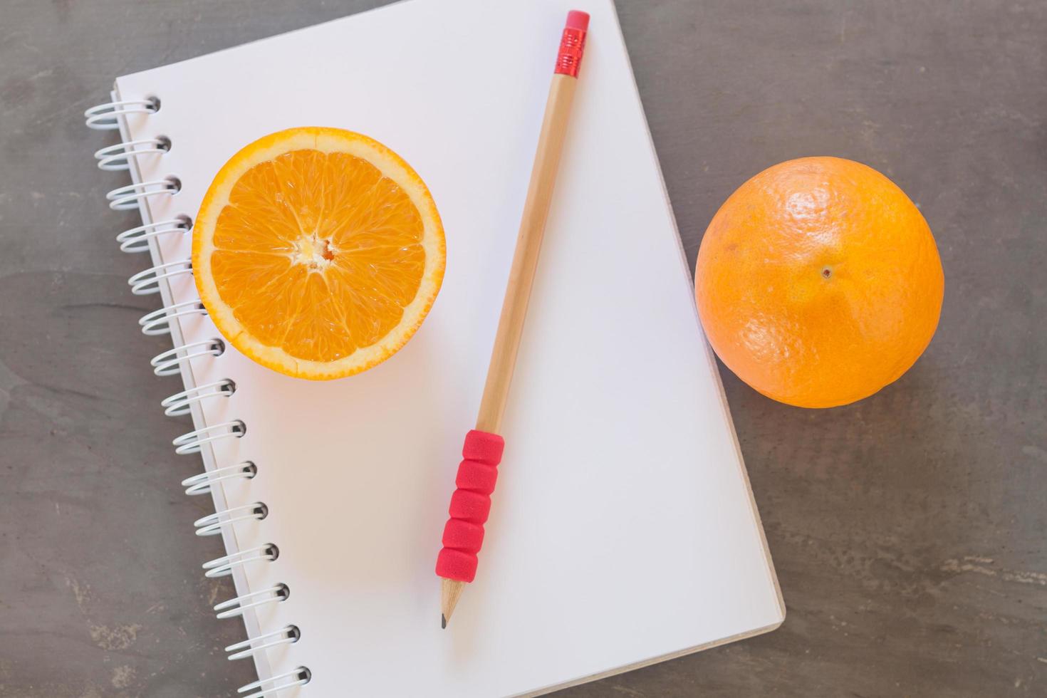 crayon rouge et oranges avec un cahier photo