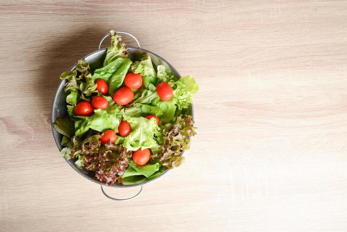 Salade fraîche aux légumes et verts sur table en bois photo