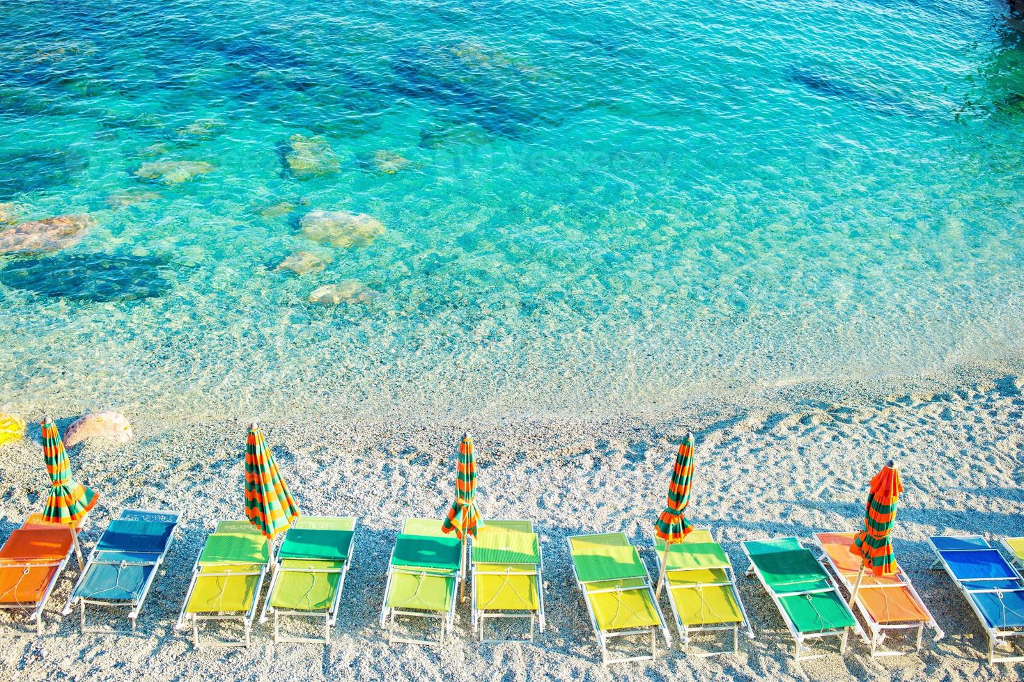 transats et parasols au beau bord de mer européen à monterosso en italie, cinque terre, ligurie photo