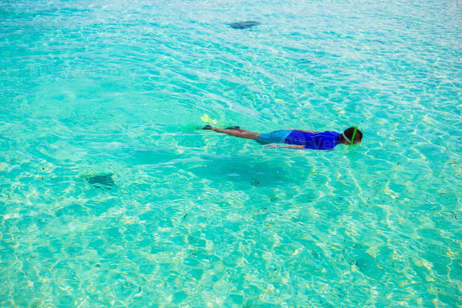 jeune garçon plongée en apnée dans l'océan tropical turquoise photo