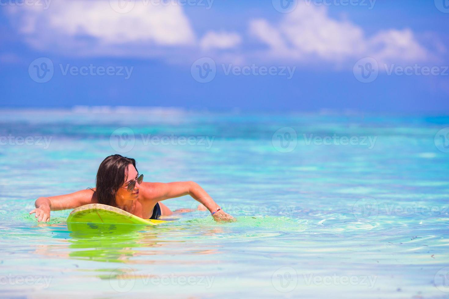 Belle surfeuse de remise en forme surfant pendant les vacances d'été photo