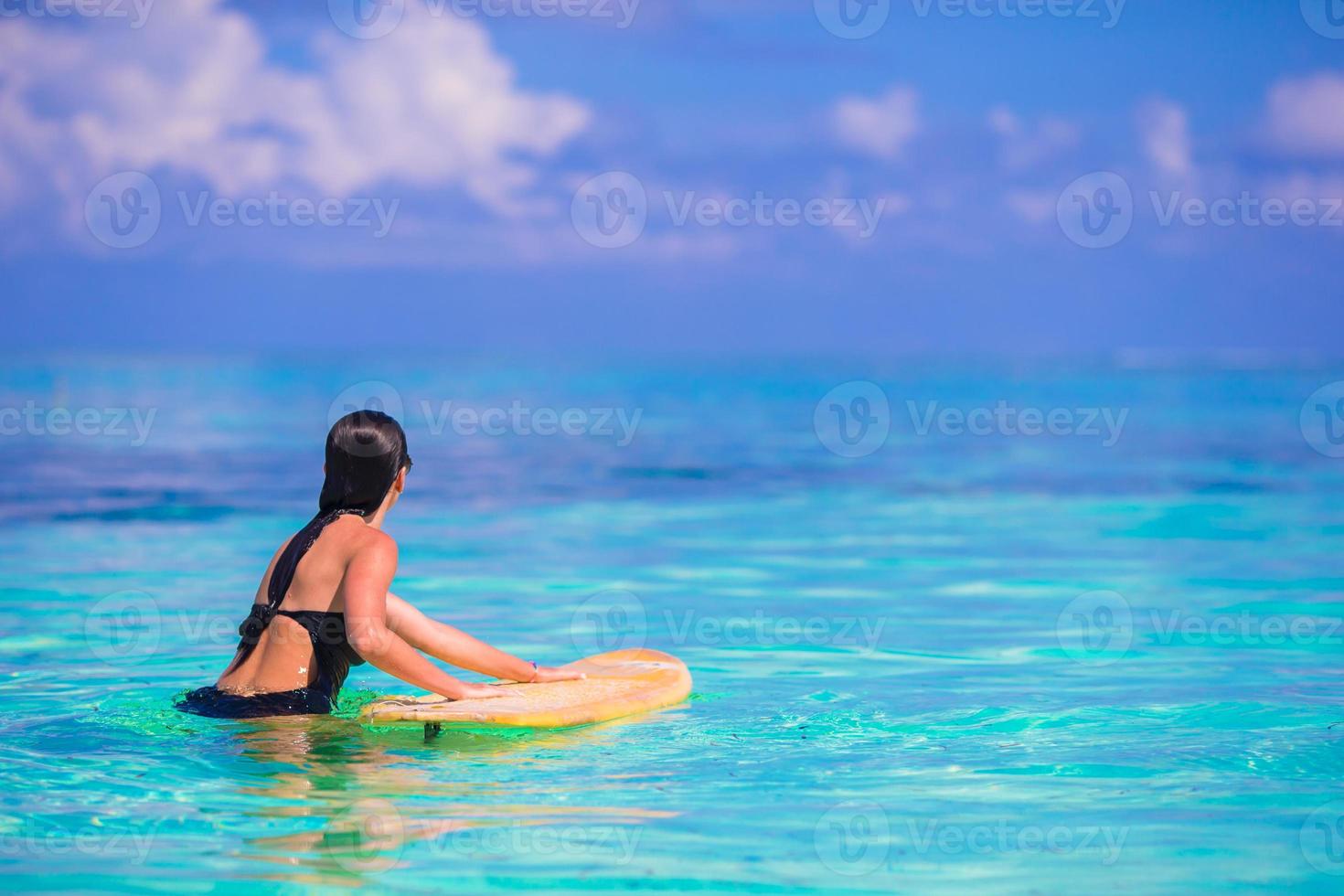 Belle surfeuse de remise en forme surfant pendant les vacances d'été photo