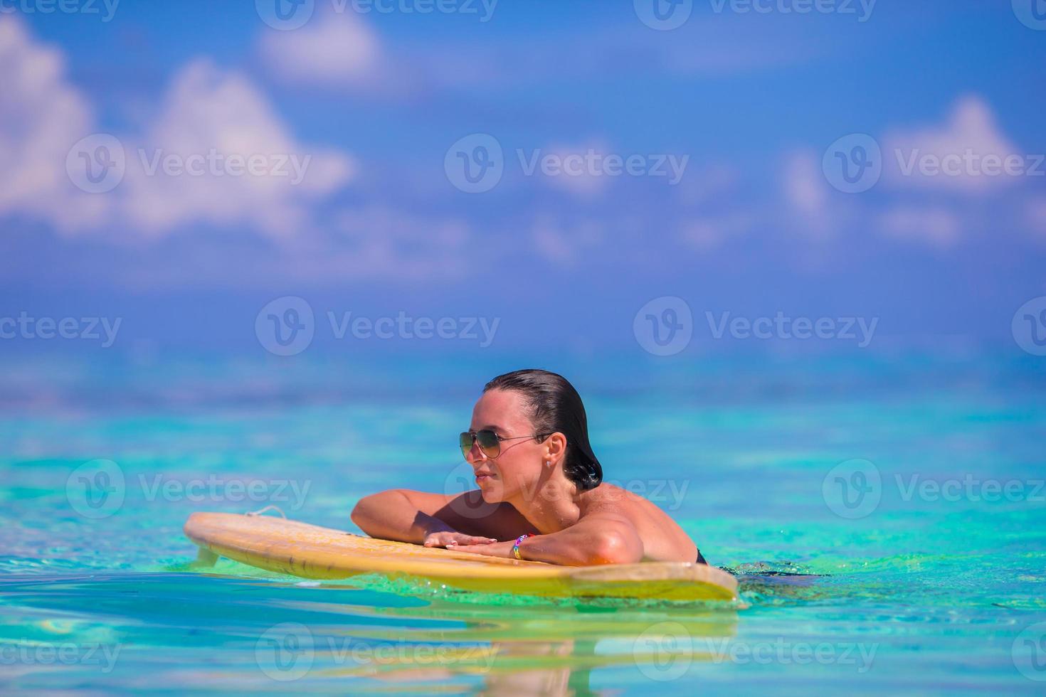 Belle surfeuse de remise en forme surfant pendant les vacances d'été photo