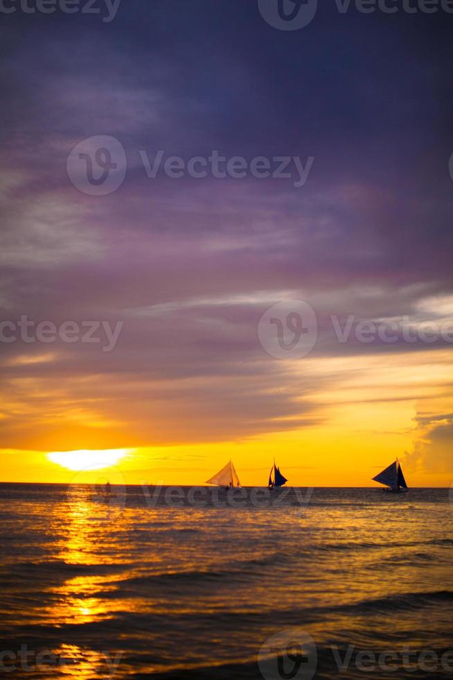 beau coucher de soleil coloré avec voilier à l'horizon sur l'île de boracay photo