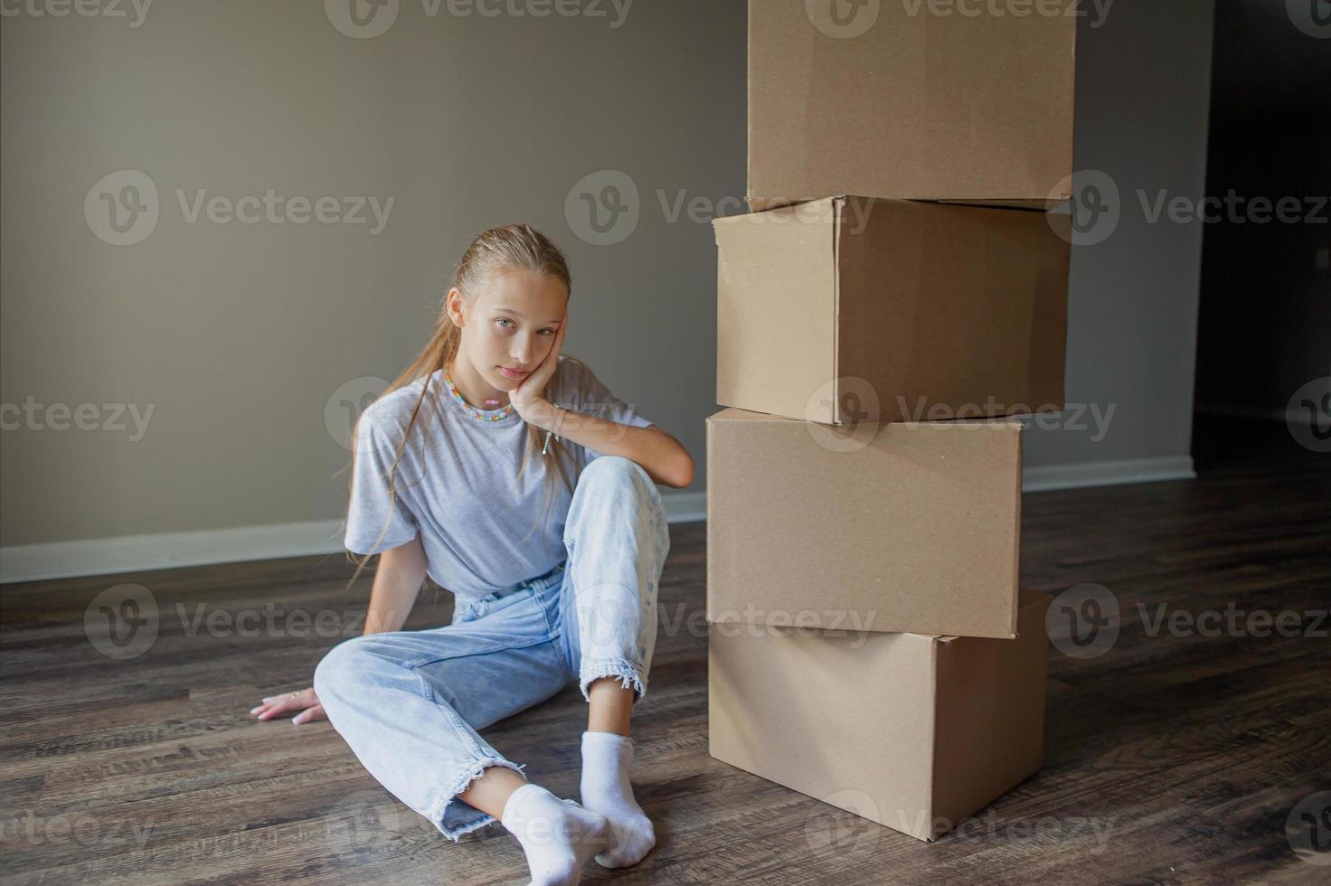 belle jeune fille emménageant dans une nouvelle maison avec des boîtes en carton photo