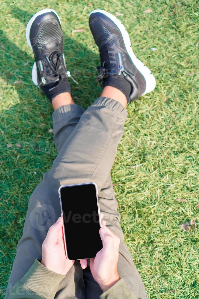 gros plan de mains masculines tient un téléphone portable à l'extérieur dans la rue. homme utilisant un smartphone mobile. photo