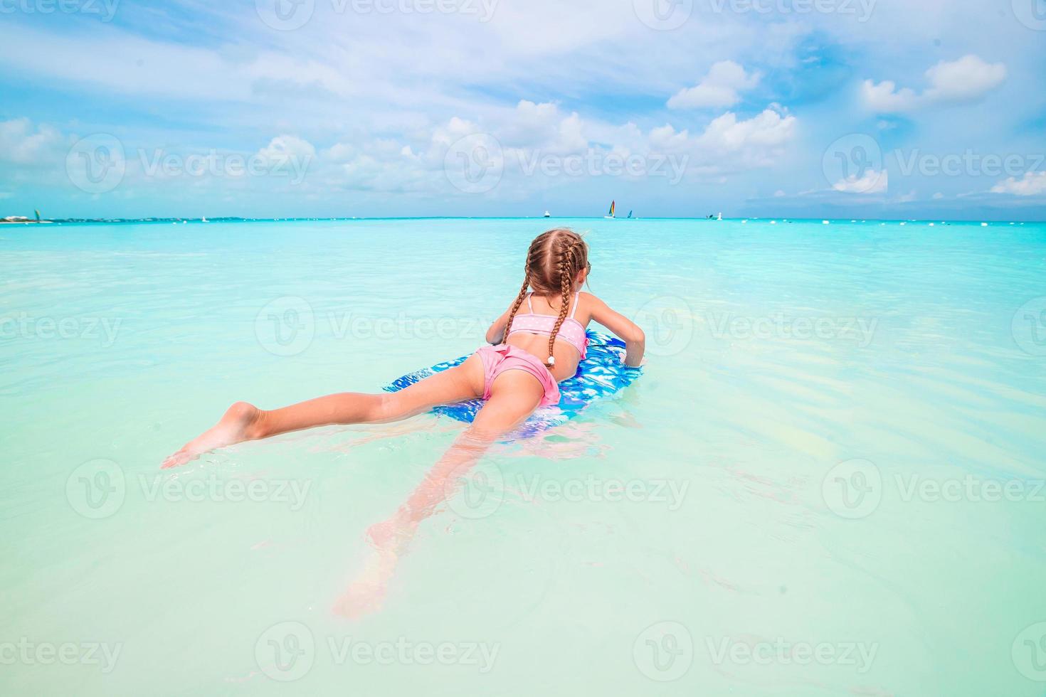 petite fille se reposant sur un matelas pneumatique gonflable dans la mer photo