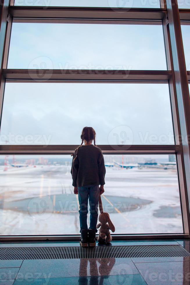 petite fille à l'aéroport près de la grande fenêtre en attendant l'embarquement photo