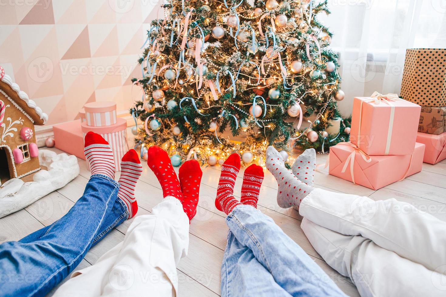 la photo en gros plan des pieds de la famille dans des chaussettes en laine près de l'arbre de Noël