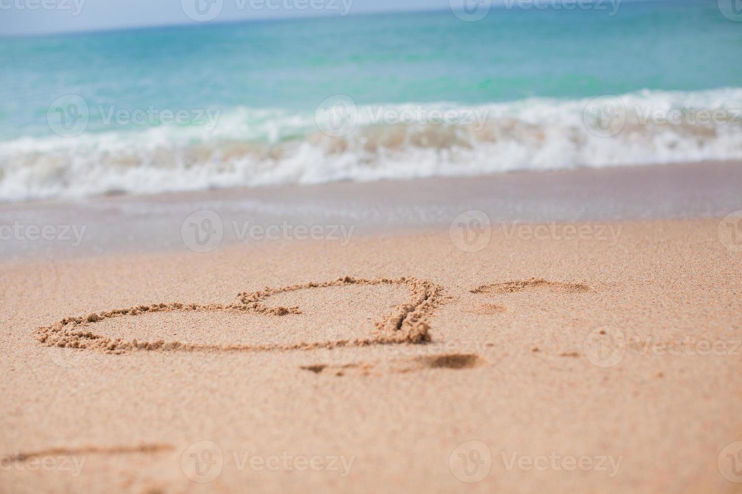 coeur peint dans le sable sur une plage tropicale photo