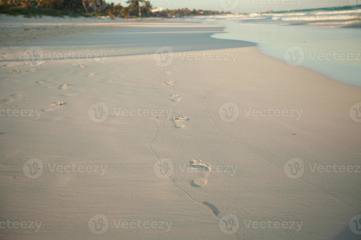 Empreintes humaines sur la plage de sable blanc tropical à tulum, mexique photo