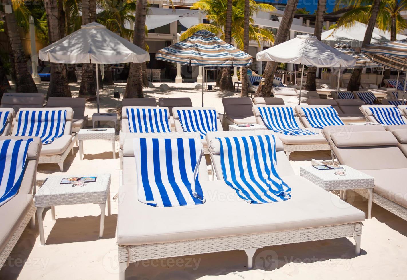 chaises de plage dans un complexe exotique sur une plage de sable blanc parfaite photo