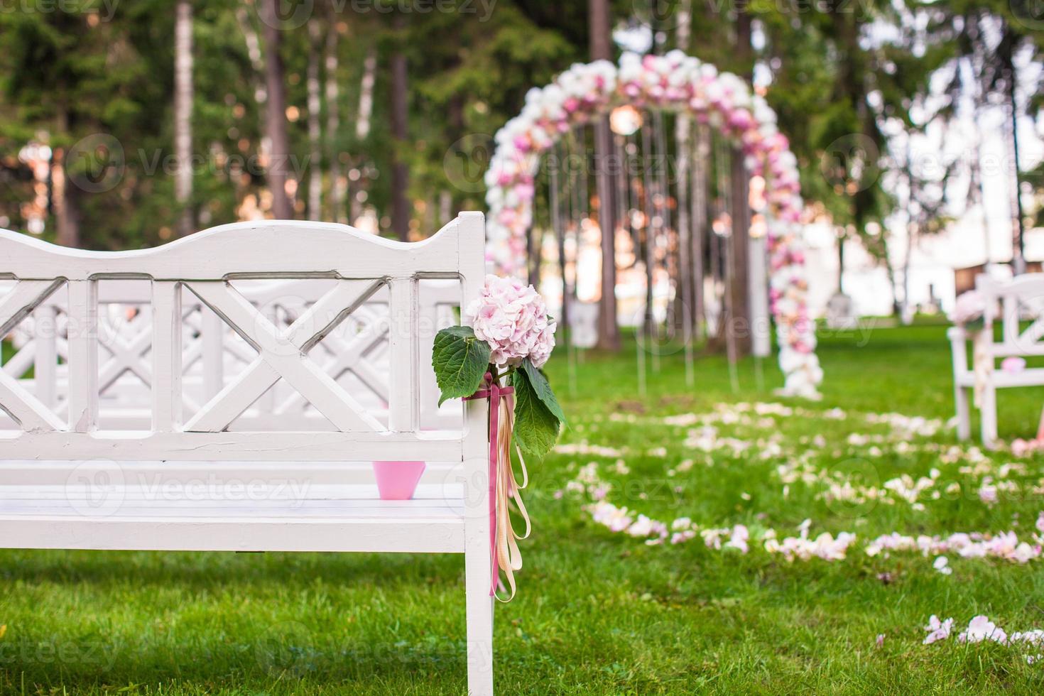 bancs de mariage et arche de fleurs pour cérémonie en plein air photo