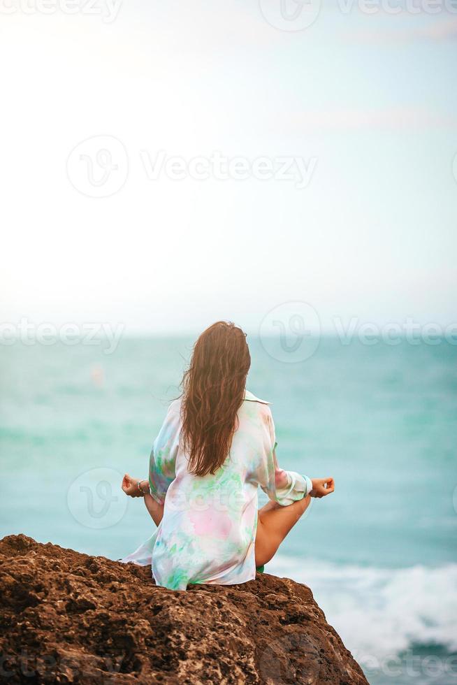 jeune femme pratiquant le yoga sur la plage photo