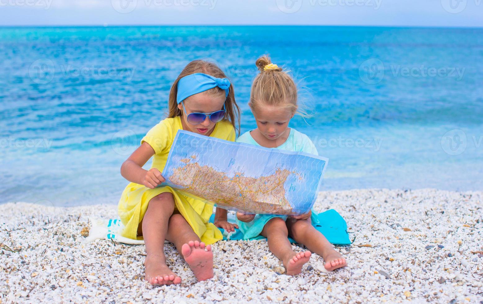 adorables petites filles avec carte de l'île sur la plage tropicale photo
