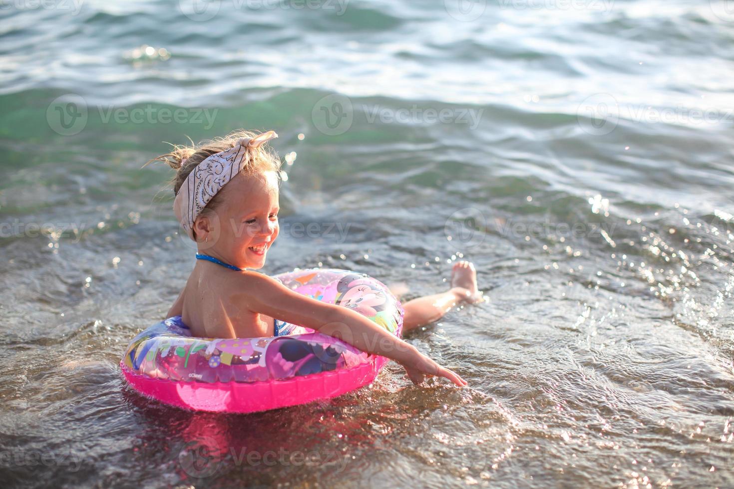 petite fille s'amusant sur une plage tropicale avec de l'eau turquoise de l'océan photo