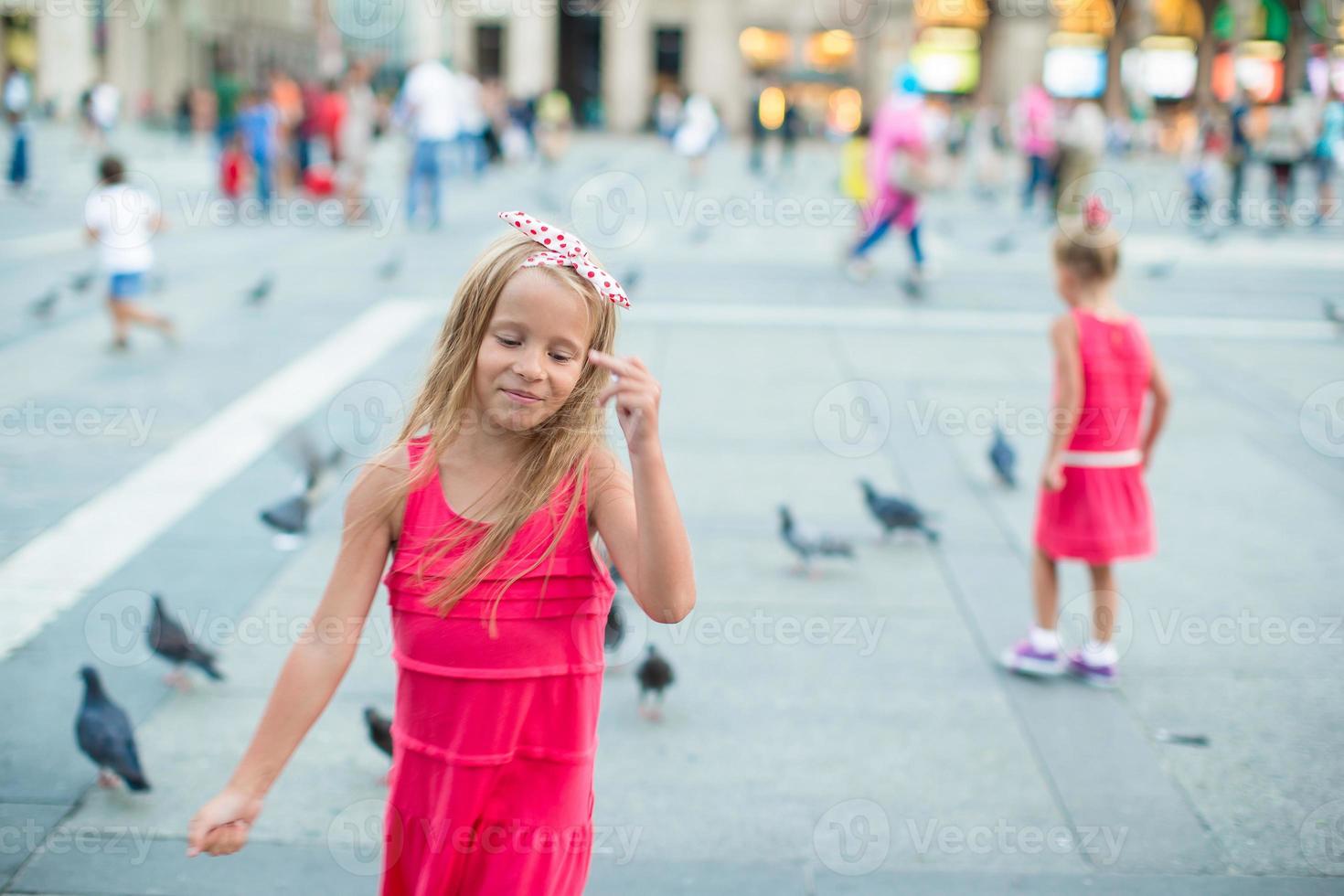 Petite belle fille marchant sur la place devant le Duomo, Milan, Italie photo