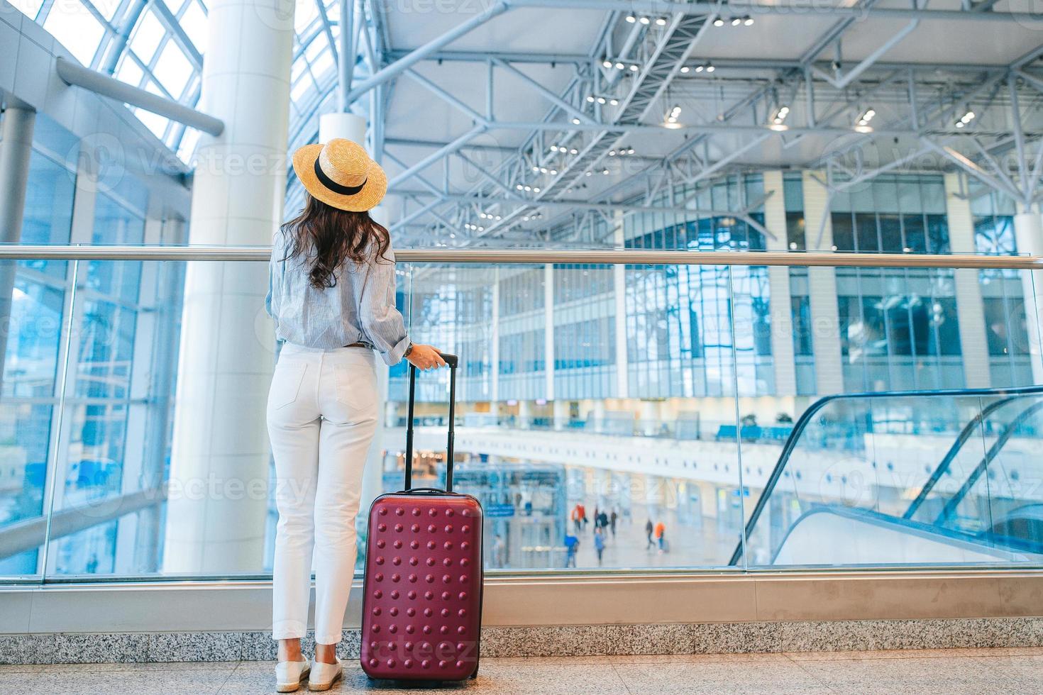 jeune femme au chapeau avec bagages à l'aéroport international. photo