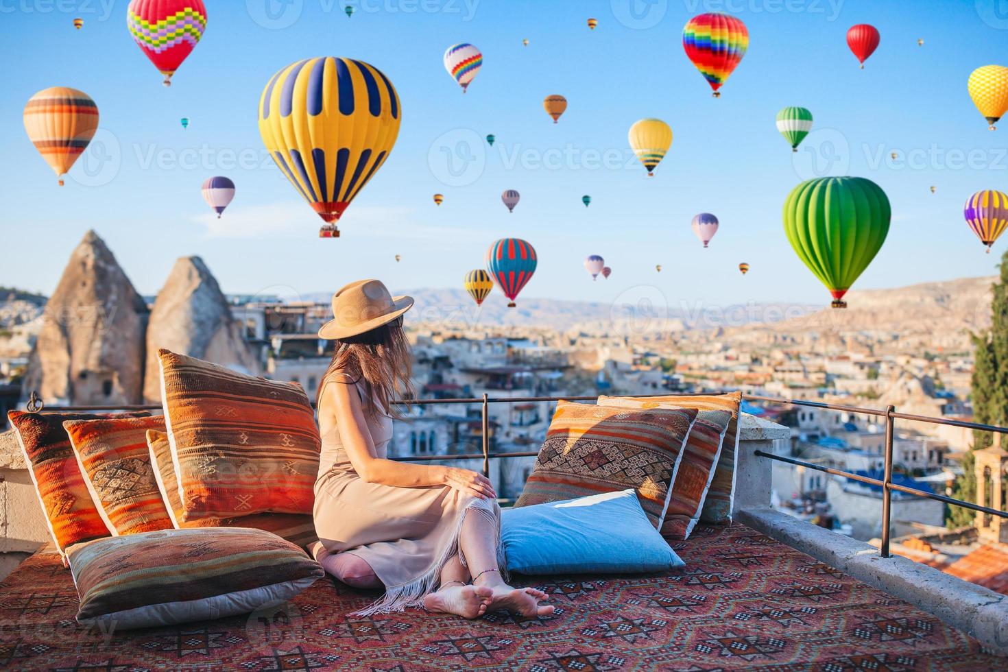 jeune femme heureuse au lever du soleil en regardant des montgolfières en cappadoce, en turquie photo