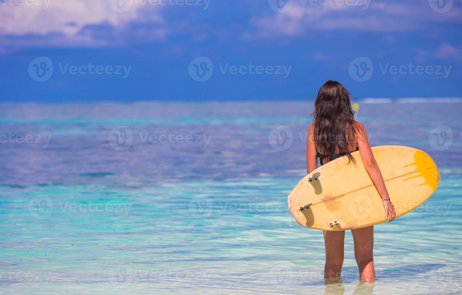 Belle surfeuse surfant pendant les vacances d'été photo