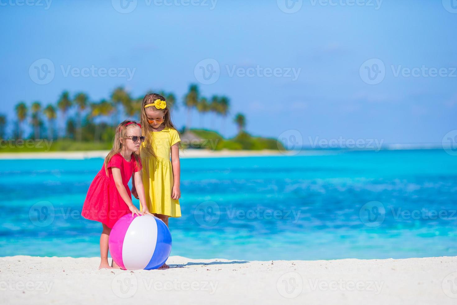 petites filles adorables jouant sur la plage avec air ball photo