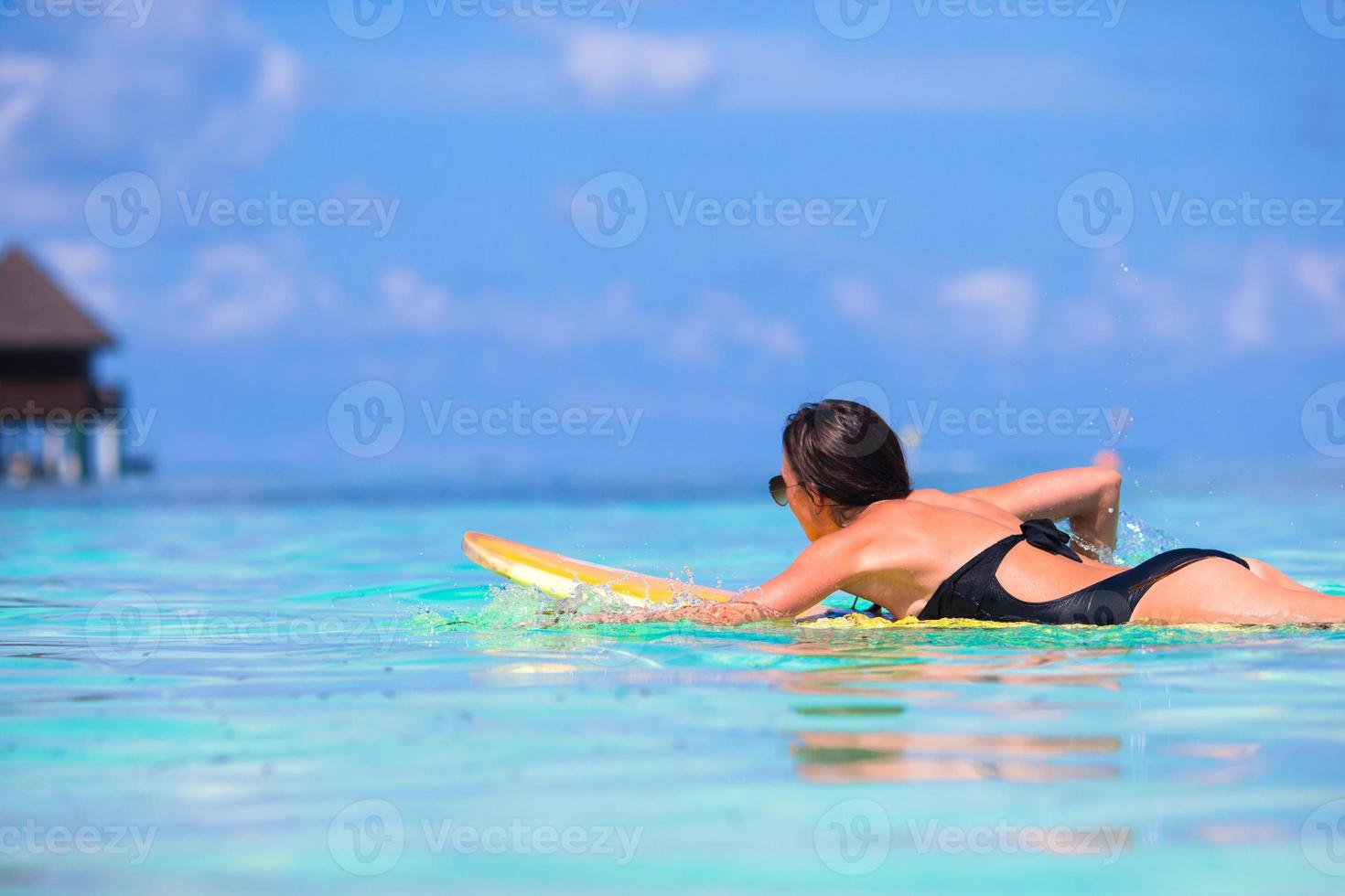 jeune surfeuse surfant pendant les vacances à la plage photo