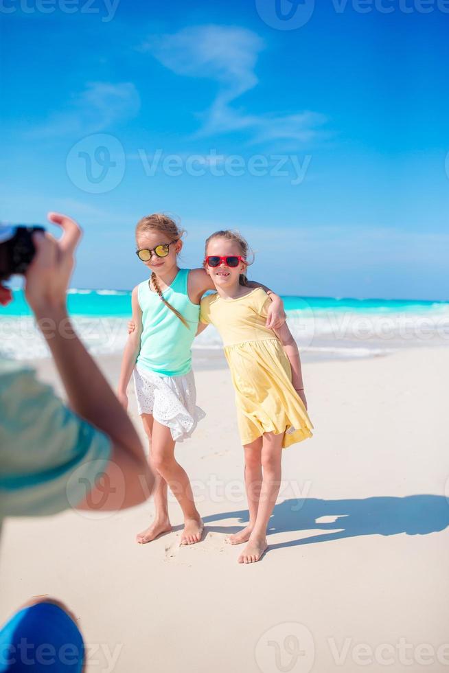 le père prend une photo de ses petites filles sur une plage tropicale blanche sur l'île des caraïbes s'amuse beaucoup