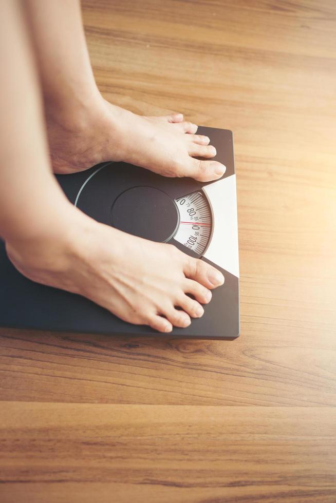 pieds de femme debout sur une échelle de poids photo