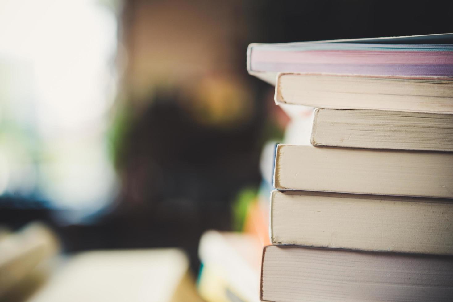 Des piles de livres sur une table sur un arrière-plan flou de la bibliothèque photo