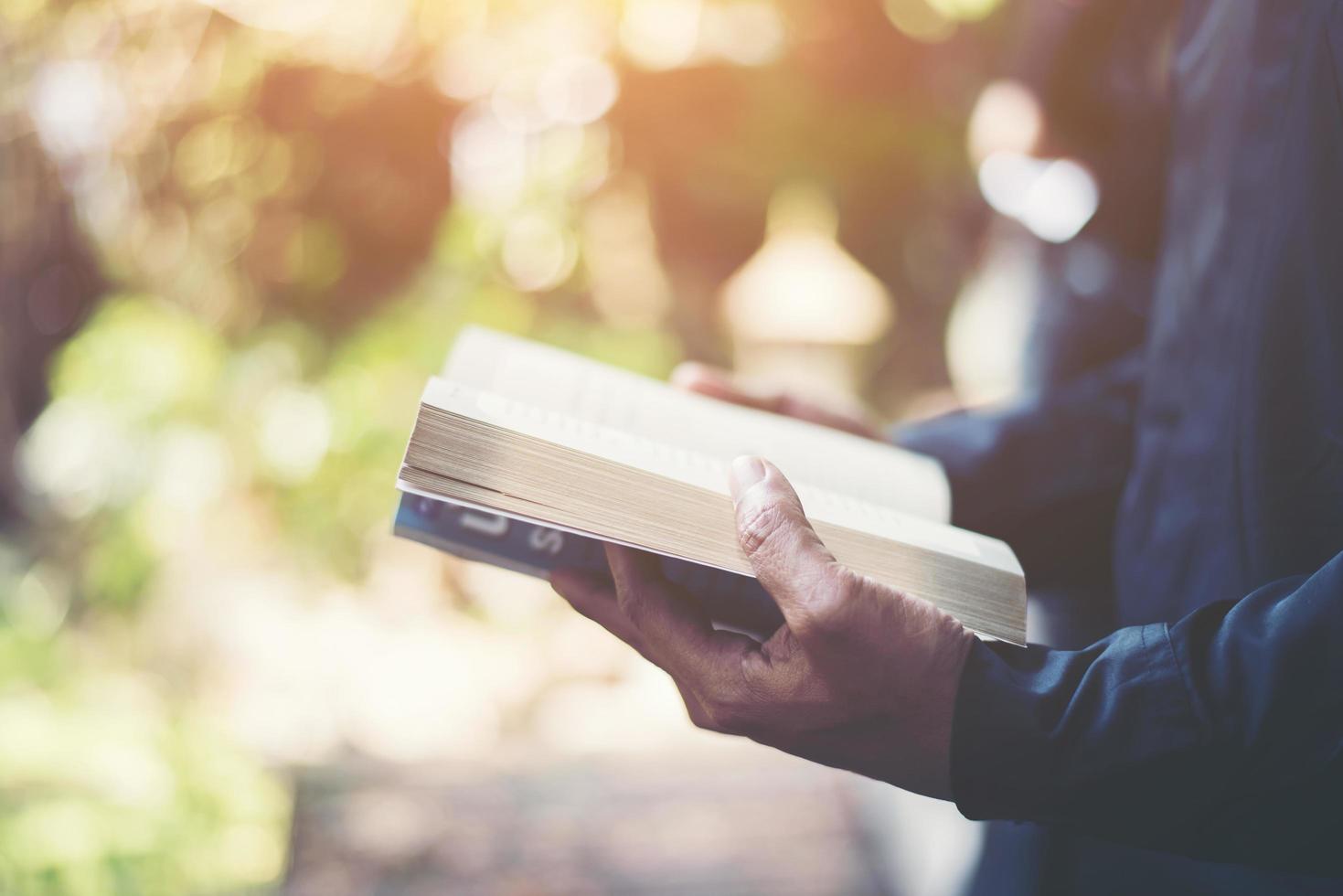 homme lisant un livre dans ses mains photo