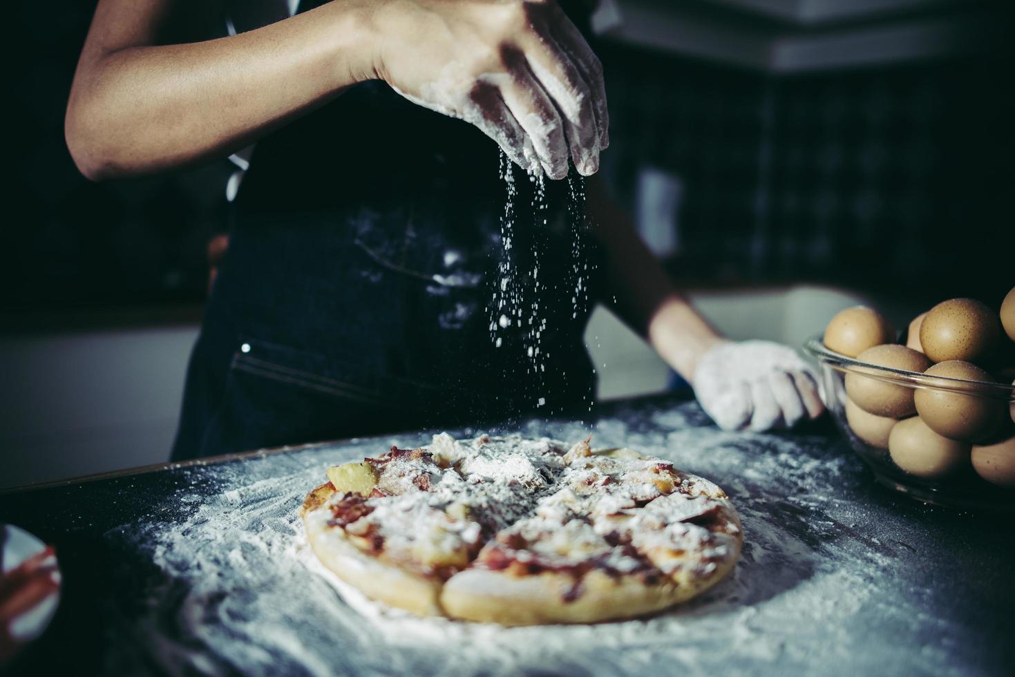 mains du chef, verser la farine sur la pâte crue photo