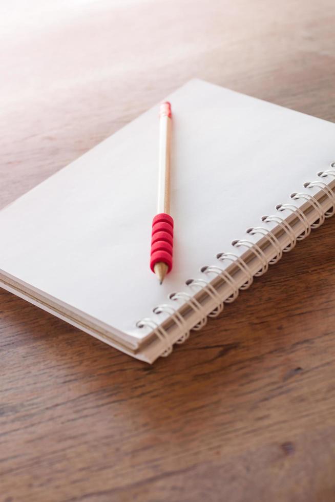 crayon rouge et un cahier au soleil photo