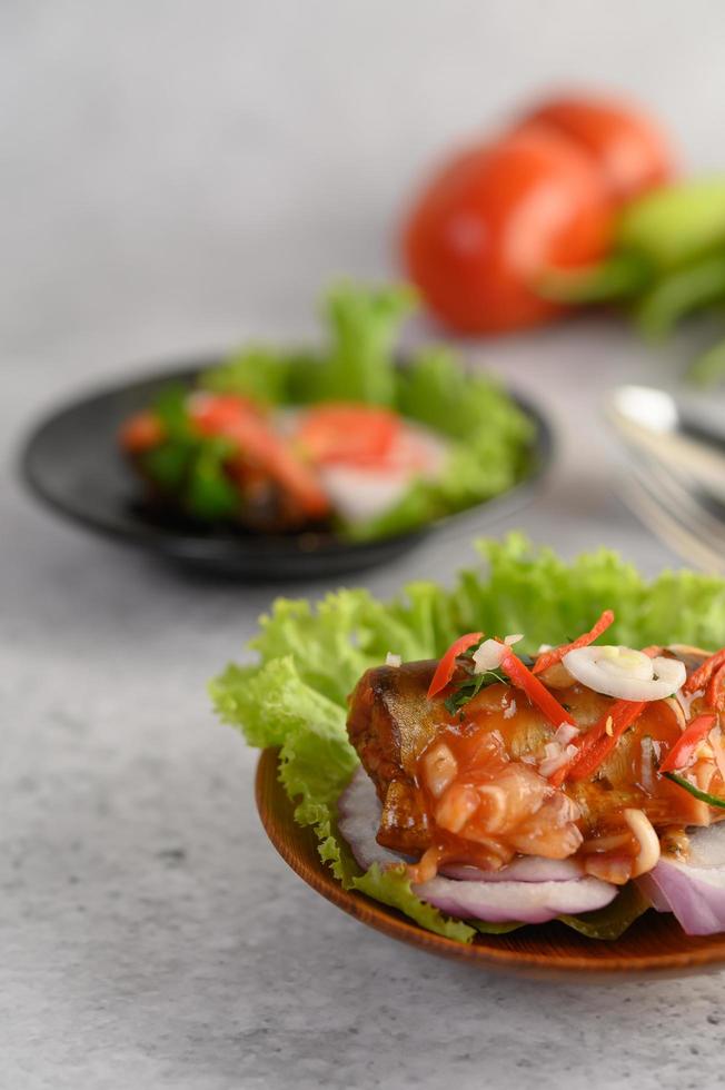 Salade de sardines épicées dans un bol en bois photo